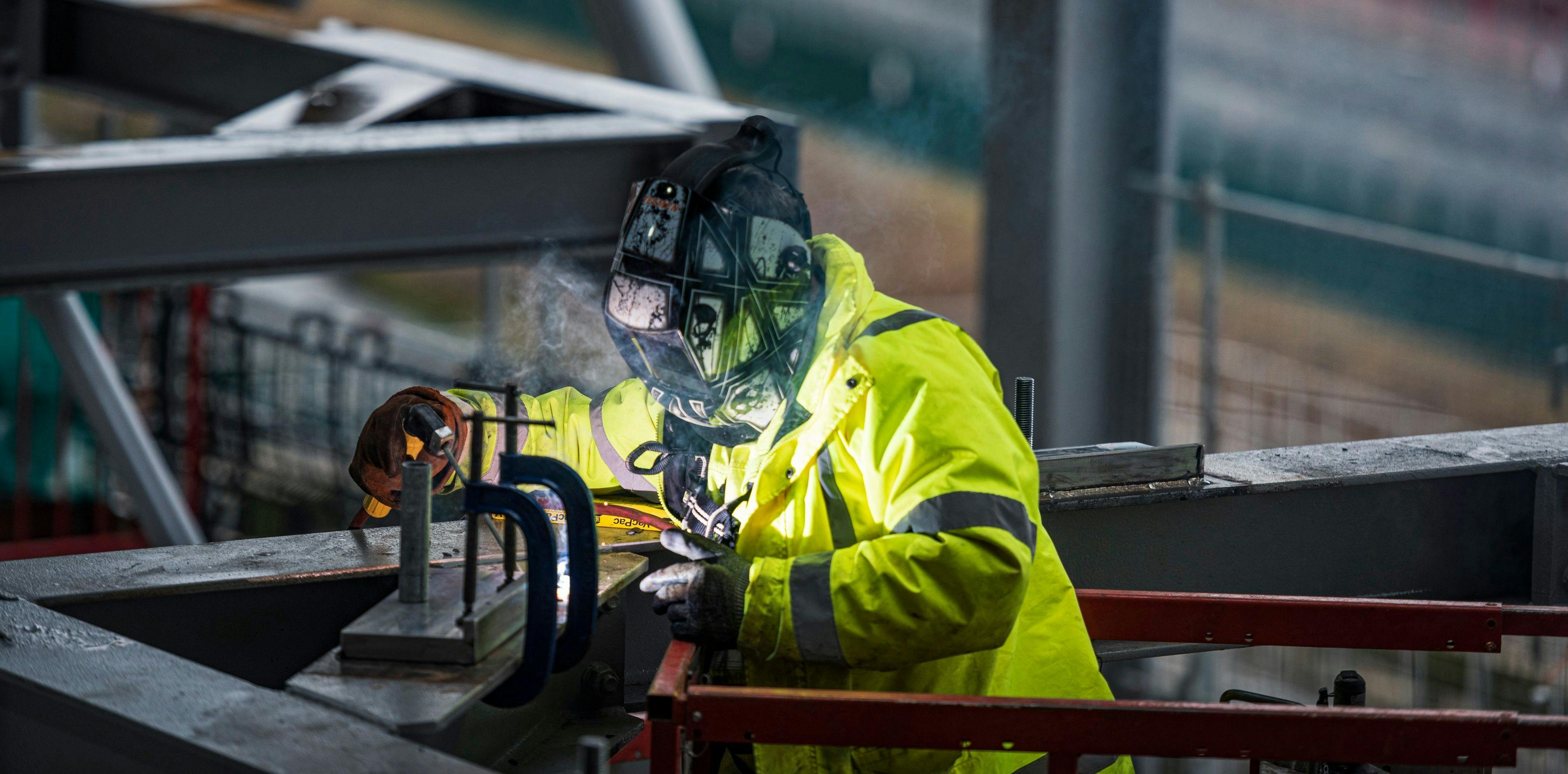 A man welding in a visibility suit
