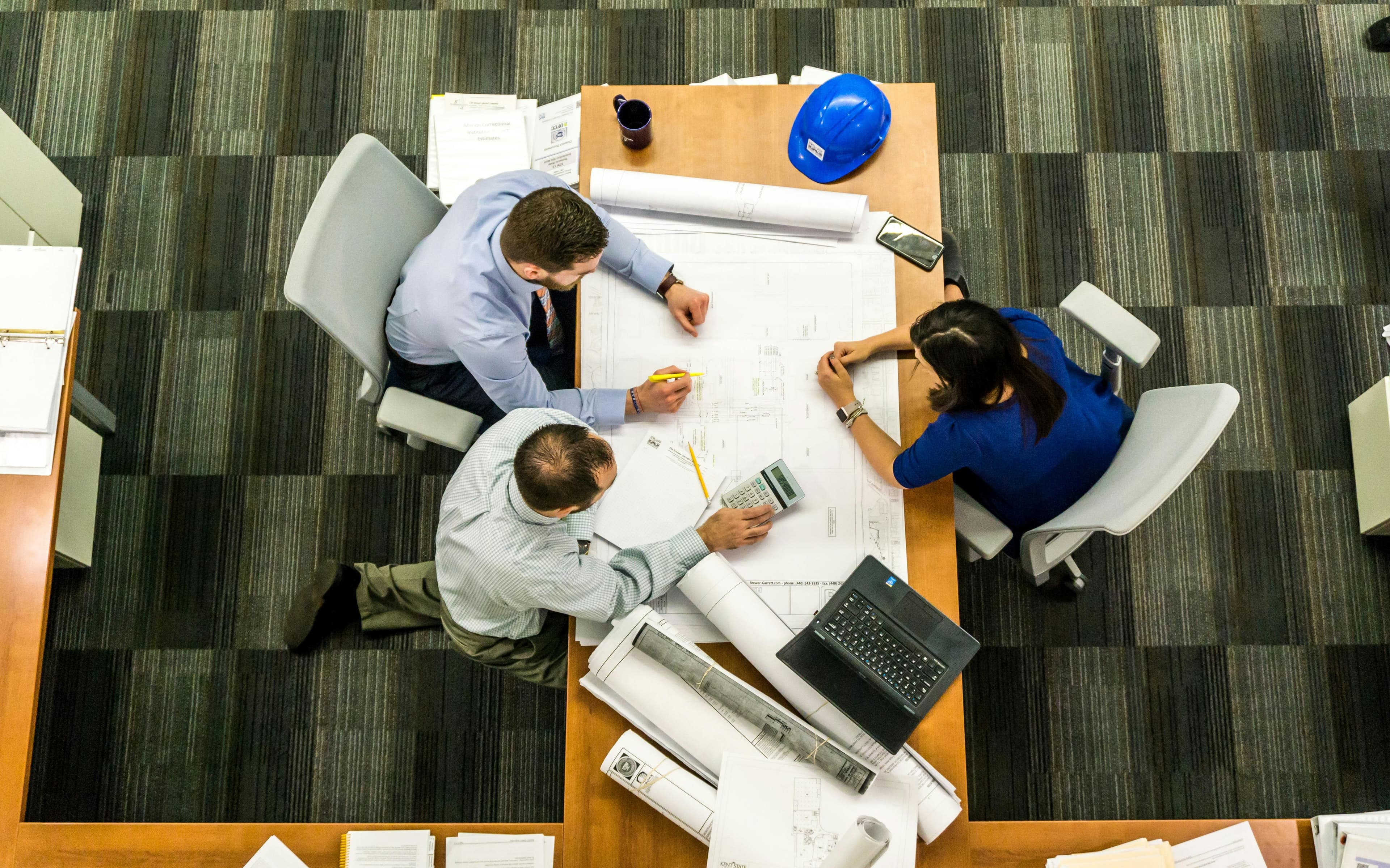 A desk with of 3 engineers at work 